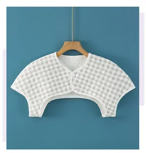 Detail view of grey plaid quilted shoulder warmer with white buttons and trim
