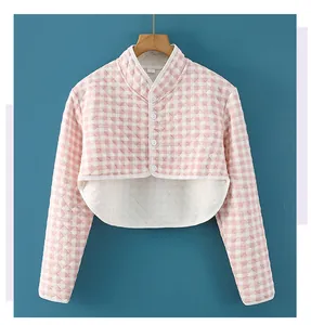 Detail of pink plaid quilted shoulder protector with high collar and white button closure