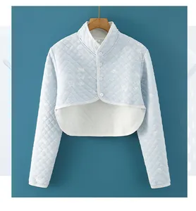 Detail of light blue quilted cotton shoulder warmer with cat patterns and button closure