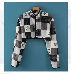 Detailed view of checkered fleece shoulder warmer featuring snowflake patterns and buttons