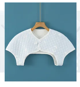 Detail of quilted cotton shoulder warmer with footprint pattern and button closure