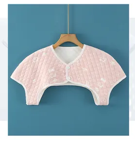 Detailed view of pink quilted thermal shoulder wrap with white cartoon cat patterns