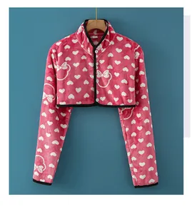 Détail du chauffe-épaule en flanelle rose rouge avec motifs de cœur et boutons