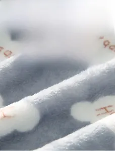 Close-up of soft light blue flannel fabric with cloud patterns and thick plush texture