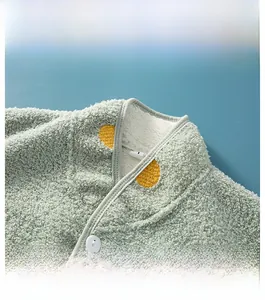 Dettaglio del collo alto in pile verde menta con pois gialli e fodera in peluche