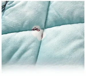 Close-up of soft light blue coral fleece fabric with happy cartoon pattern and fine stitching