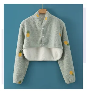 Macro detail of soft green sherpa fleece shoulder wrap with yellow pineapple pattern
