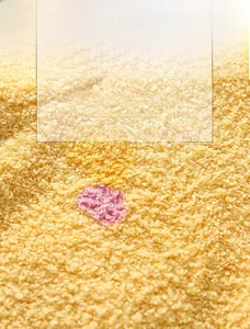 Nahaufnahme von weichem gelbem Fleece mit bunten Punkten für Kinderschulterschutz