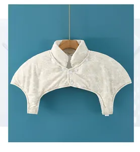 Detailed view of beige thermal shoulder protector with quilted fabric and button closure