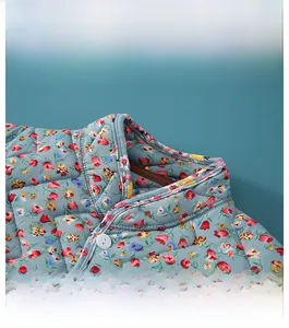 Detail of floral quilted shoulder wrap showing stand collar and button closure
