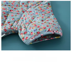 Detailed close-up of quilted floral shoulder warmer with reinforced four-needle stitching