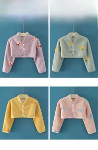 Detail von vier bunten Fleece-Schulterwärmern für Kinder mit süßen Fruchtstickereien