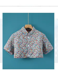 Close-up of quilted floral shoulder warmer with diamond stitching and white buttons