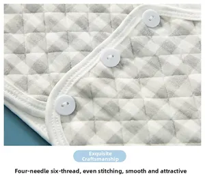 Détail de gilet matelassé pour bébé avec couture fine à quatre aiguilles et bouton blanc