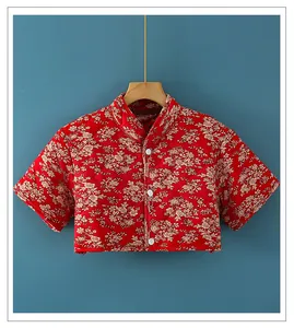 Detailed view of red floral quilted shoulder warmer with mandarin collar and white buttons