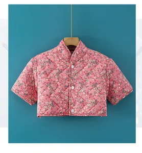 Detailed view of quilted floral shoulder warmer jacket with short sleeves and buttons