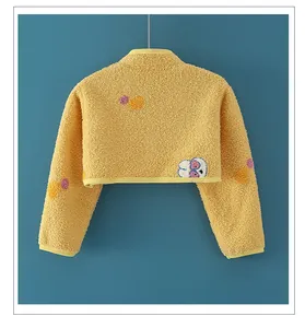 Detail eines gelben Fleece-Schulterwärmers für Babys mit süßem Cartoon-Rückenprint