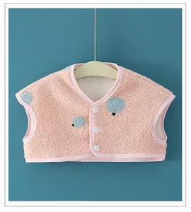 Detail of pink fleece baby shoulder warmer vest with blue polka dots and white buttons