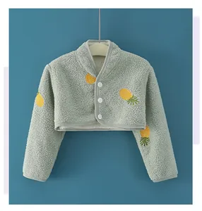 Nahaufnahme des Baby-Schulterschutzes aus Milchfleece mit Ananas-Stickerei und Knöpfen