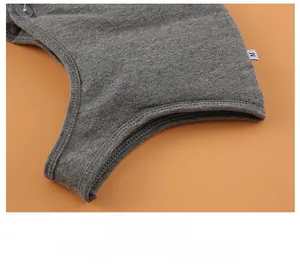 Close-up of grey thermal neck warmer with fine stitching, button, and M size label