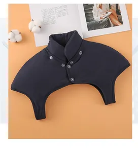 Detail of navy blue high collar shoulder protector with 5 buttons on pink backdrop