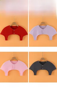 Detailed view of knitted shoulder warmer with button closure in red, purple, pink and black