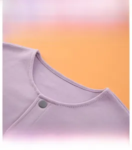 Close-up of the purple shoulder warmer with a round neckline and snap button detail