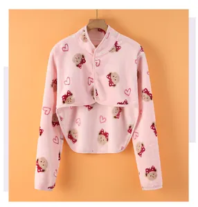 Detailed view of pink fleece shoulder warmer with bear pattern and button closure