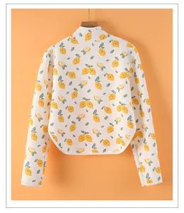 Detailed macro view of quilted texture and lemon prints on the long sleeve warm shoulder cape
