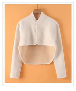Detailed view of cream shoulder wrap with textured bear patterns and orange lining