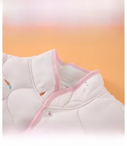 Detail of pink quilted infant vest showing mandarin collar and snap button closure