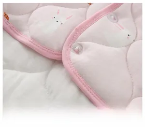 Close-up of quilted thermal shoulder wrap showing pink rabbit prints and snap buttons