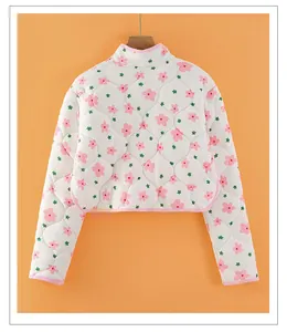 Detailed close-up of floral quilted thermal shoulder warmer with pink piping trim