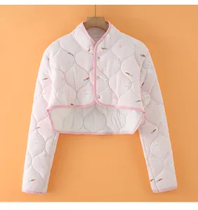 Detail view of pink quilted shoulder warmer with cute rabbit print and button closure