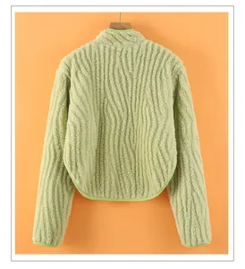 Detail view of the back of a light green plush jacket with curved hem and vibrant green piping