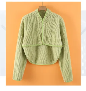 Close-up of plush light green thermal shoulder wrap with wave texture and pearl button