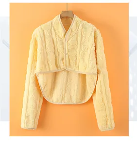 Nahaufnahme eines gelben Schulterschutzes aus Fleece mit Rippstruktur und Perlenknopf