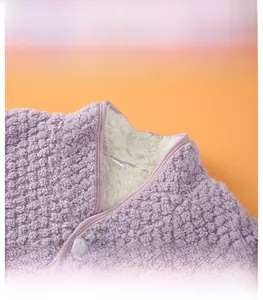Detail of purple polar fleece shoulder warmer with white faux shearling lining and buttons
