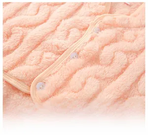 Detail of pink flannel shoulder warmer with textured twist pattern and white buttons
