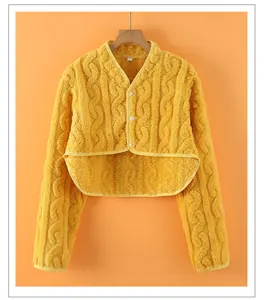 Detail of yellow flannel shoulder warmer with textured twist knit pattern and buttons