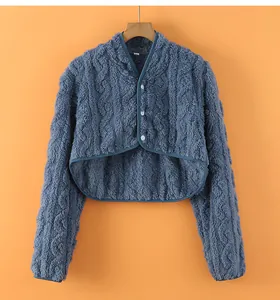 Close-up of thick blue fleece shoulder warmer with cable knit texture and white buttons