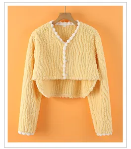 Detailed view of yellow fleece shoulder warmer with lace trim and soft plush texture