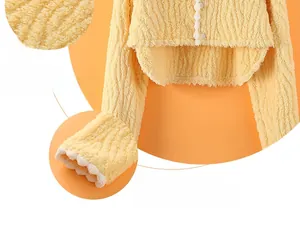 Close-up of soft yellow plush fabric texture and cuffs with white wavy lace details