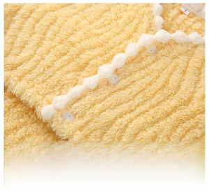 Close-up of ginger flannel shoulder wrap showing white wavy lace trim and button detail