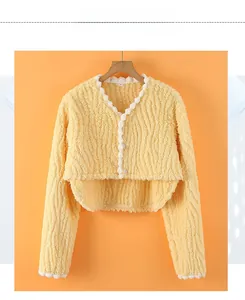 Detailed view of yellow flannel shoulder wrap with wavy texture and white lace trim