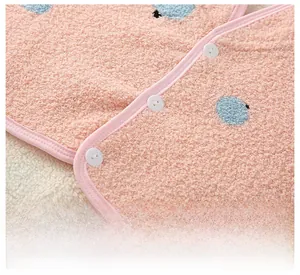 Close-up of pink flannel fabric with blue dots and fine stitching on the shoulder wrap