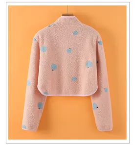 Macro detail of a pink polka dot fleece shoulder warmer with curved hem and soft texture