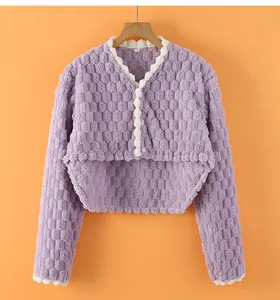 Detail of purple velvet shoulder warmer with honeycomb texture and white scalloped edges