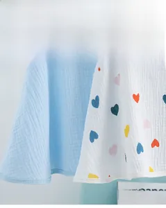 Close-up of soft cotton nursing shawl showing blue fabric and colorful heart pattern