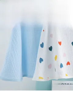 Close-up of lightweight cotton nursing shawl fabrics in blue and heart patterns